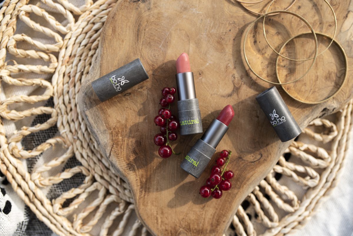 Rtěnky Boho Green Rouge v šedých pouzdrech na dřevěném prkénku s červeným rybízem
