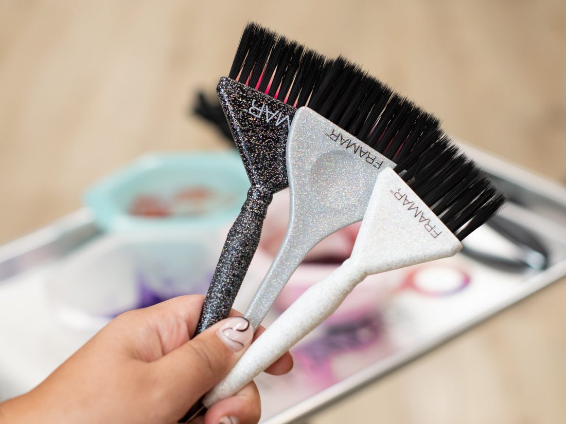 Tři třpytivé štětce Framar Glitter Family Pack v ruce kadeřnice