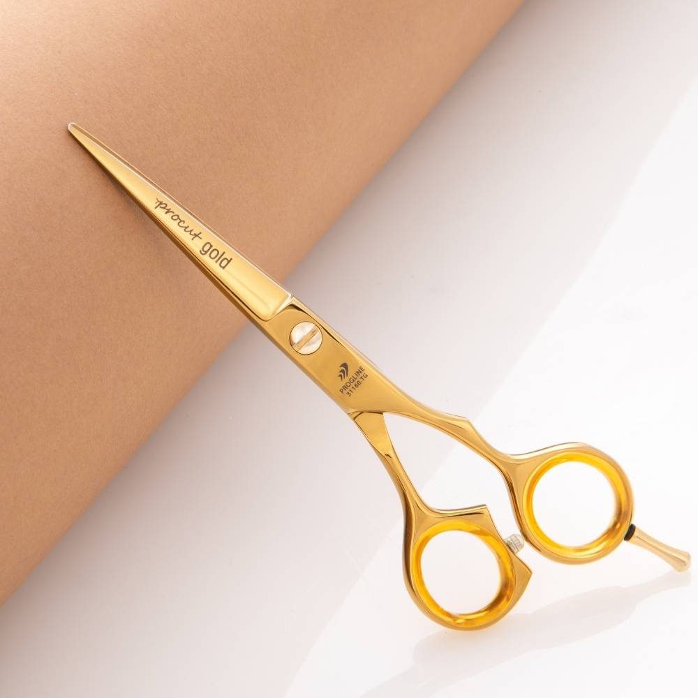 Zlaté kadeřnické nůžky Progline Procut Gold 6″ na béžovém pozadí