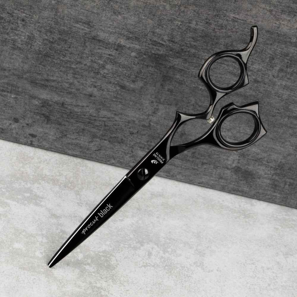 Černé kadeřnické nůžky Progline Procut Black 6,5″ netypického tvaru na tmavém pozadí