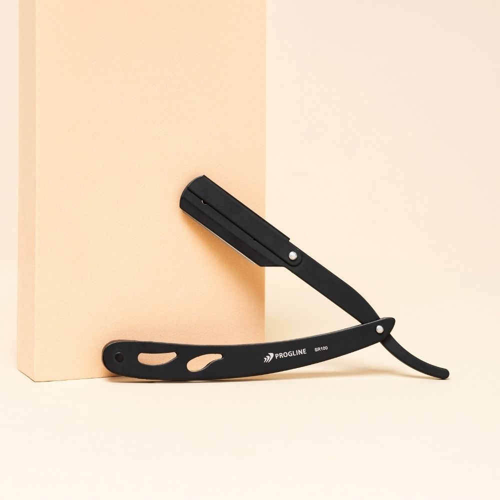 Černá břitva Progline Razor Black SR100 opřená o béžový podstavec