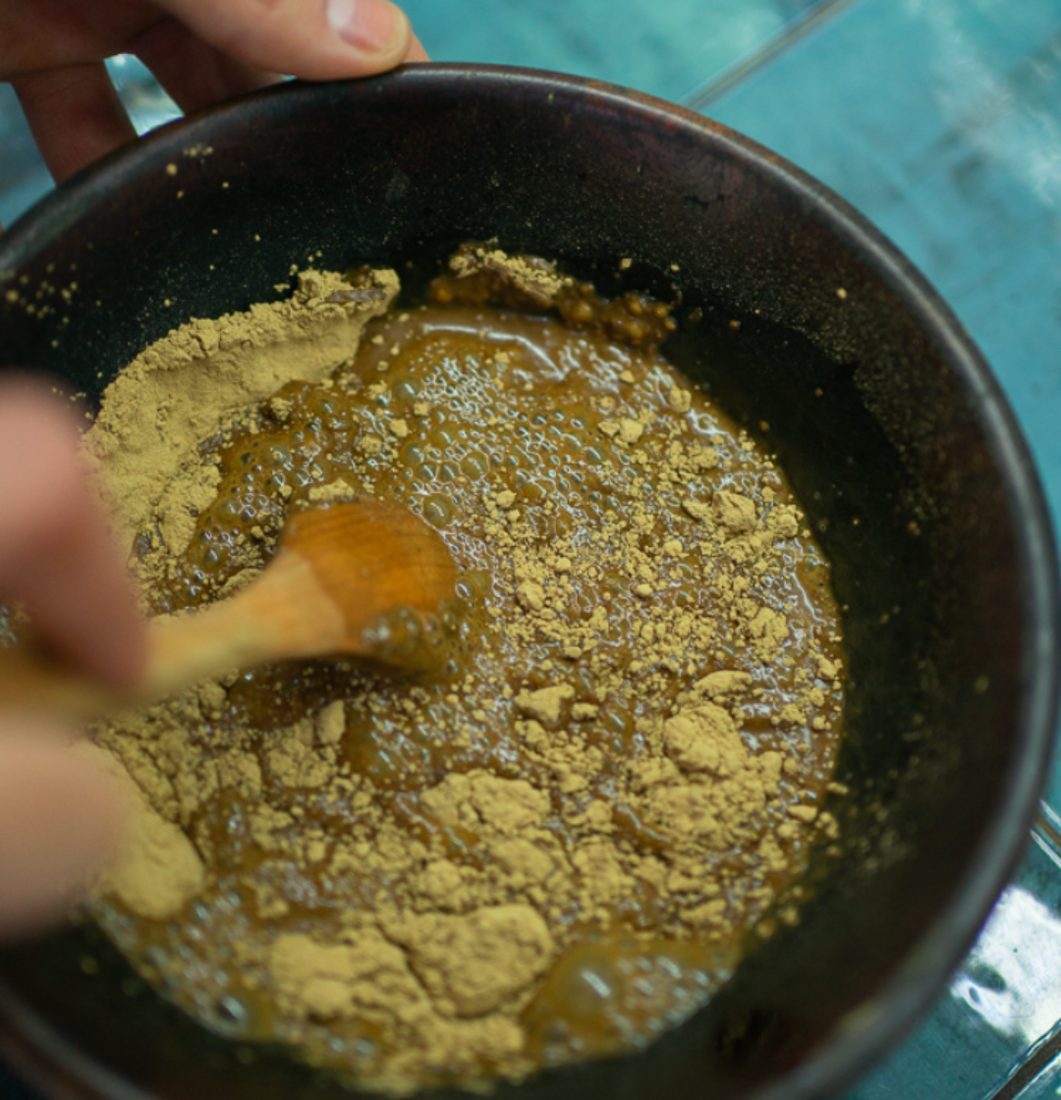 Rozmíchaná henna v misce s dřevěnou stěrkou